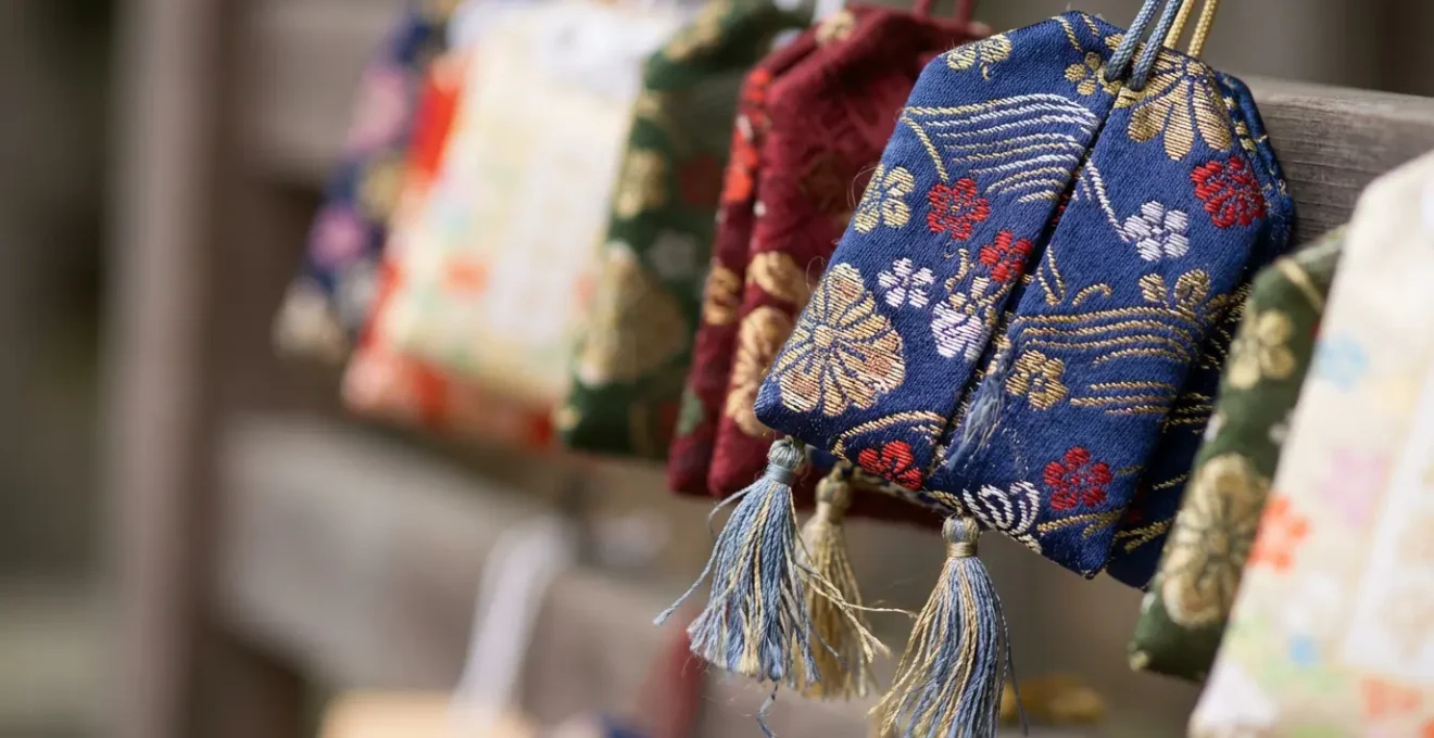 Collection d'omamori colorés suspendus avec leurs cordons décoratifs